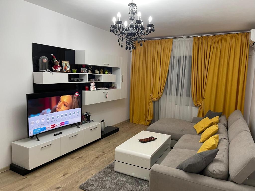 Il comprend un salon doté d'un canapé et d'une télévision à écran plat. dans l'établissement Urban Harmony Loft, à Bucarest