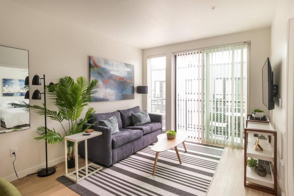 uma sala de estar com um sofá e uma planta em Top Floorbalcony55" 4k Smart Tv360 Rooftop View em Tacoma