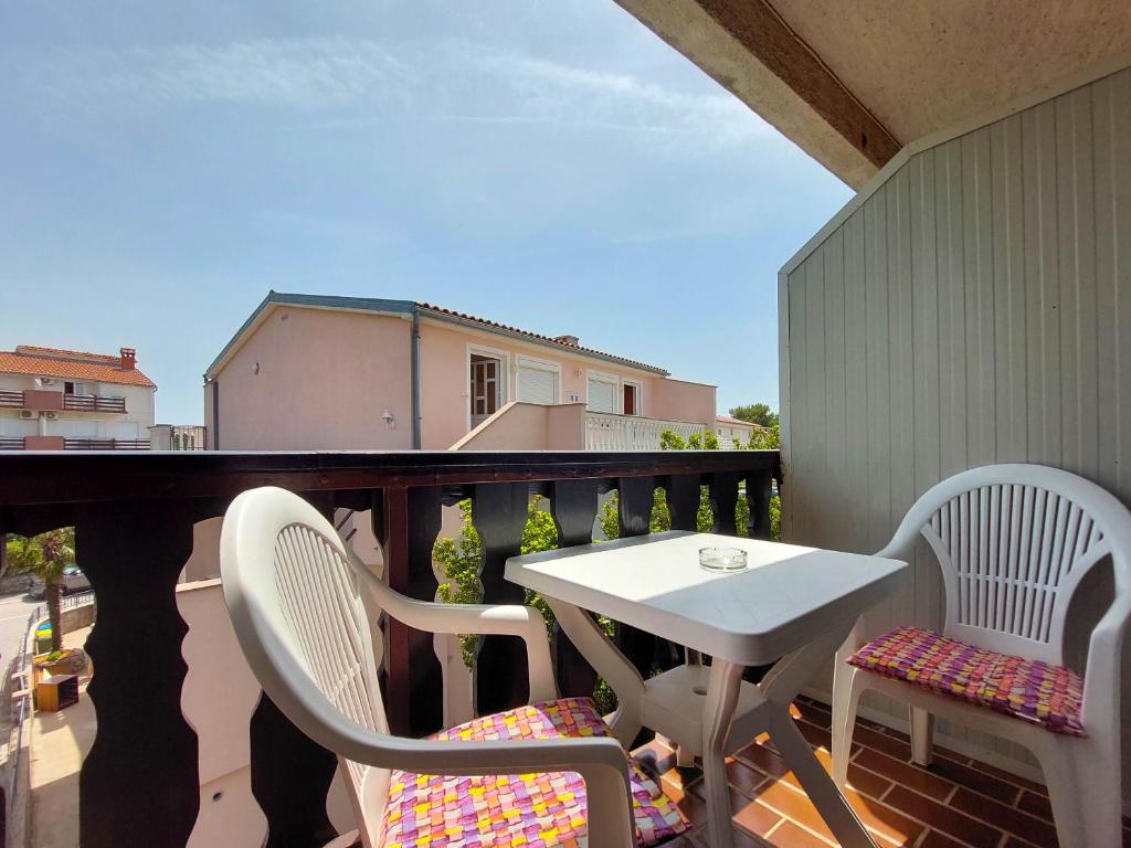 a balcony with a table and chairs on a balcony at Apartments Marija in Selce