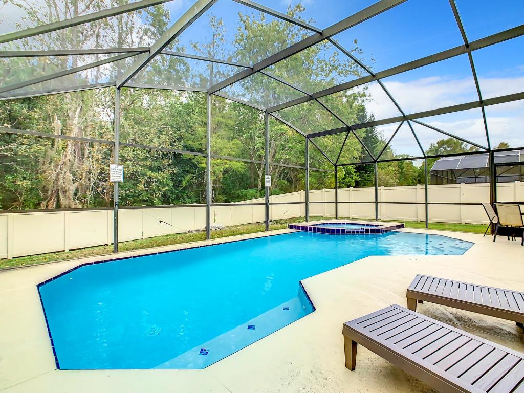 uma piscina interior com telhado de vidro em Casita mi Encanto a Cozy & Spacious House, 4-bedroom 3-Bath & pool em Kissimmee