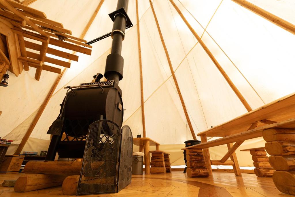 a room with a wood stove in a tent at Altipik - Lodges Insolites in Mont-Saxonnex