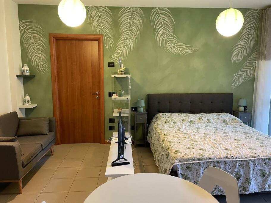 ペーロにある“The green house” Fiera Milanoのベッドと椅子とソファのある寝室