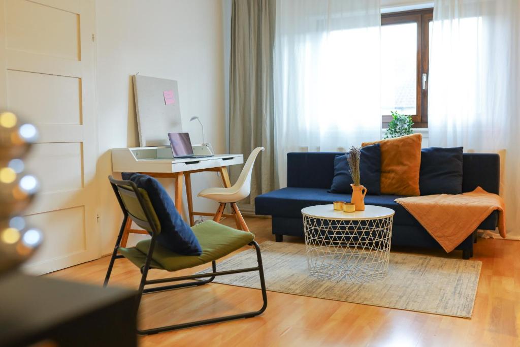 ein Wohnzimmer mit einem blauen Sofa und einem Tisch in der Unterkunft namastay! - Moderne Stadtwohnung am NTM und Blick auf den Wasserturm in Mannheim