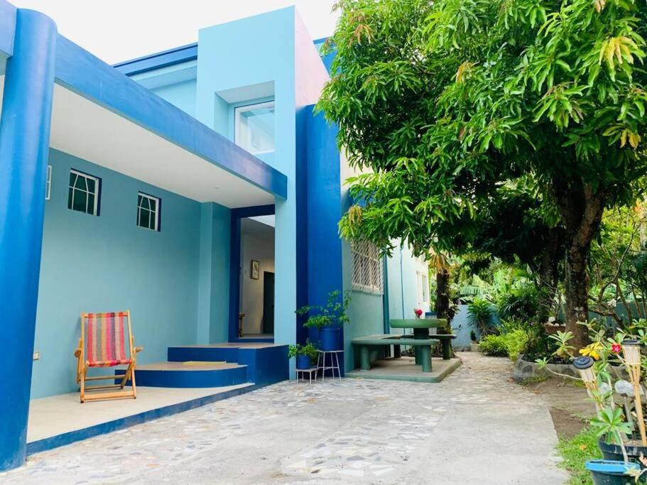 a blue building with a table and a tree at MAGAYON BLUE HOUSE IN THE HEART OF LEGAZPI in Legazpi