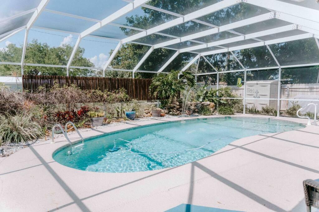 - une piscine dans une véranda avec une piscine dans l'établissement Entire home, heated pool, just 10 min to beach!, à Vero Beach