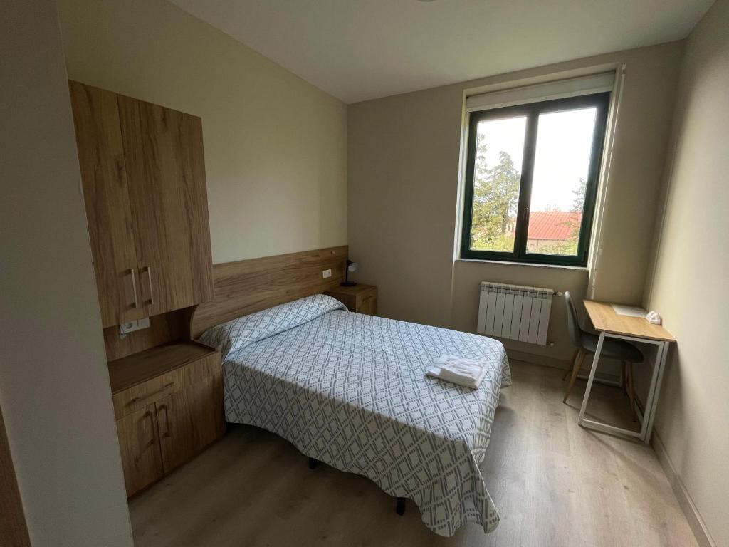 - une petite chambre avec un lit et une fenêtre dans l'établissement Casa Diocesana VIA LUCIS, à Saint-Jacques-de-Compostelle