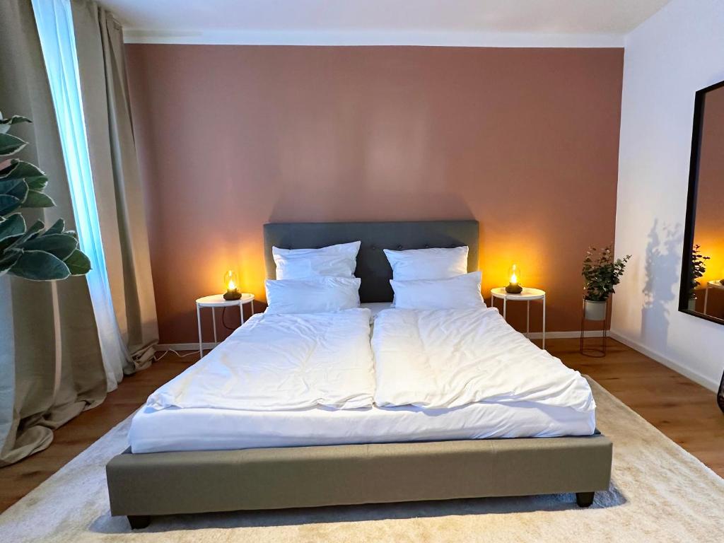 een bed met witte lakens en kussens in een slaapkamer bij Modernes City-Apartment in Möchengladbach in Mönchengladbach