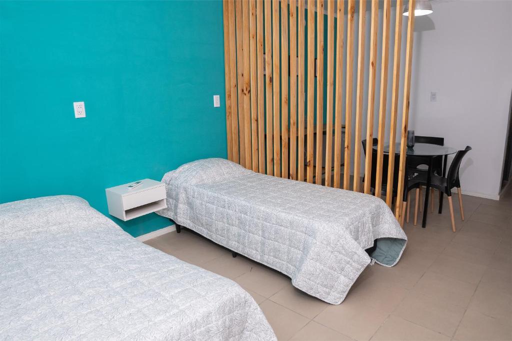 a room with two beds and a table with a desk at Alta Pinta in Paso de los Libres