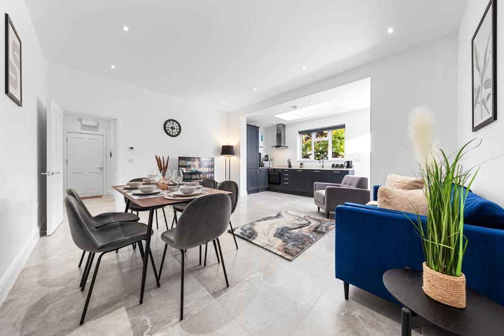 a living room with a table and a blue couch at SERCASA - Woodside Park - North Finchley in Whetstone