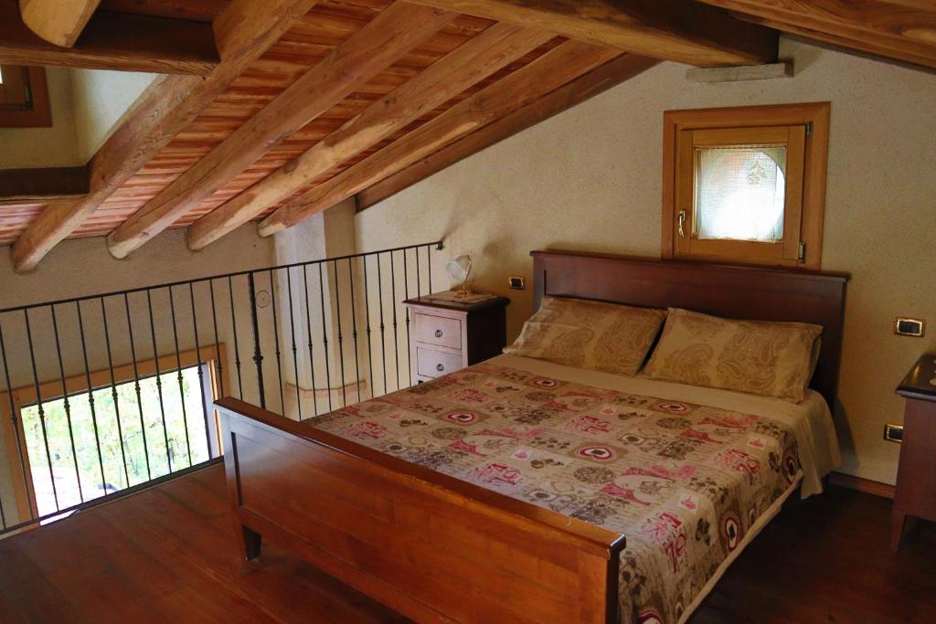 ヴァルドッビアーデネにあるAgriturismo Costa d'Orの木製の天井の客室で、ベッドルーム1室(ベッド1台付)