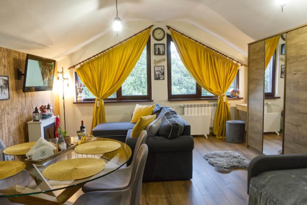 a living room with yellow curtains and a table and chairs at Borovets Dream Studio in Borovets