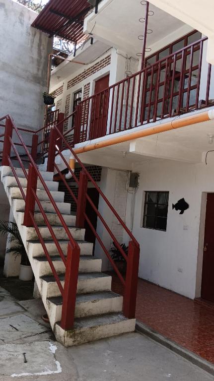 un escalier dans un bâtiment avec une rampe rouge dans l'établissement Hospedaje Casa Escondida, à Panajachel