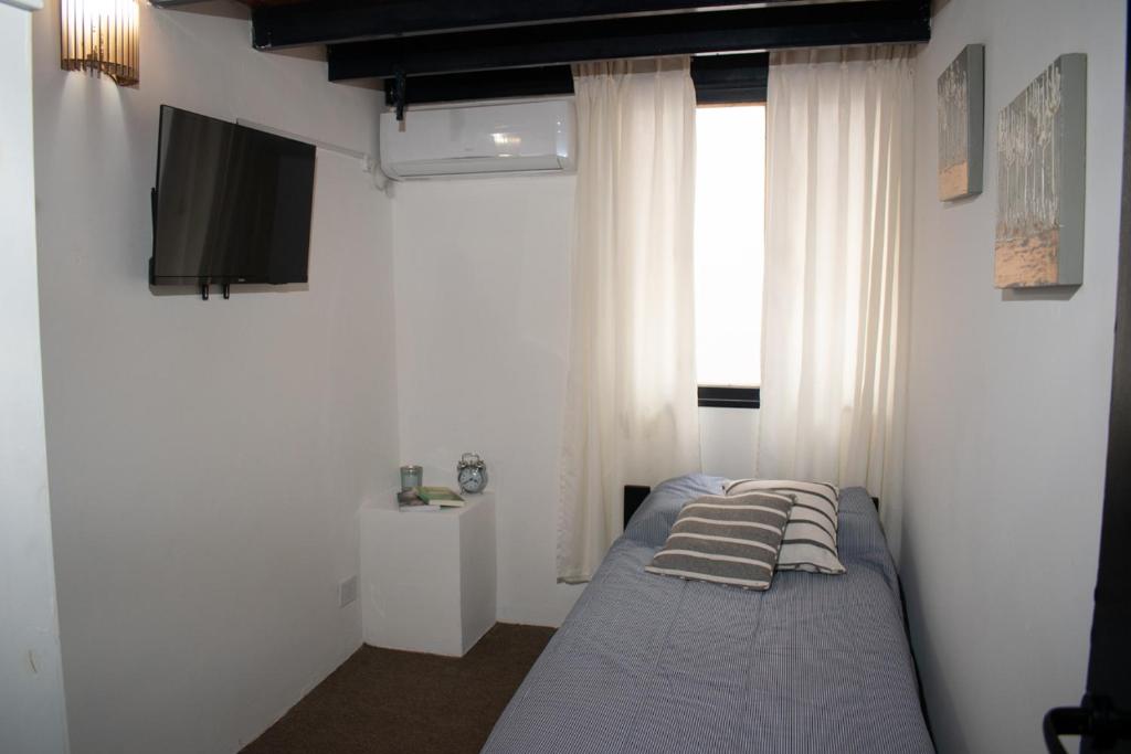 a bedroom with a bed with pillows on it at Habitaciones Temporarias CABA in Buenos Aires