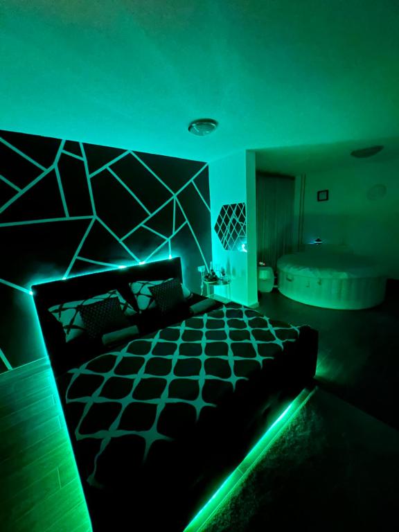 Cette chambre sombre comprend un lit et une baignoire. dans l'établissement LUXSPAKR, à Kranj