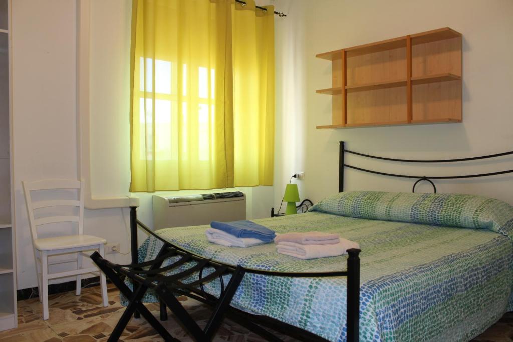 a bedroom with a bed with a table and a chair at Alghero Budget Automated check in in Alghero