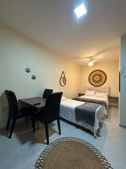 a bedroom with a bed and a desk and a table at Apartamento na praia Garopaba San Pietro Sc loft 102 in Garopaba