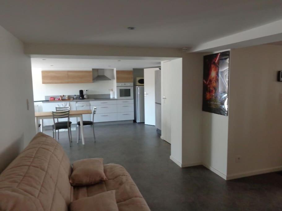 sala de estar con sofá, mesa y cocina en Appartement indépendant dans villa accessible PMR, en Saint-Chamond