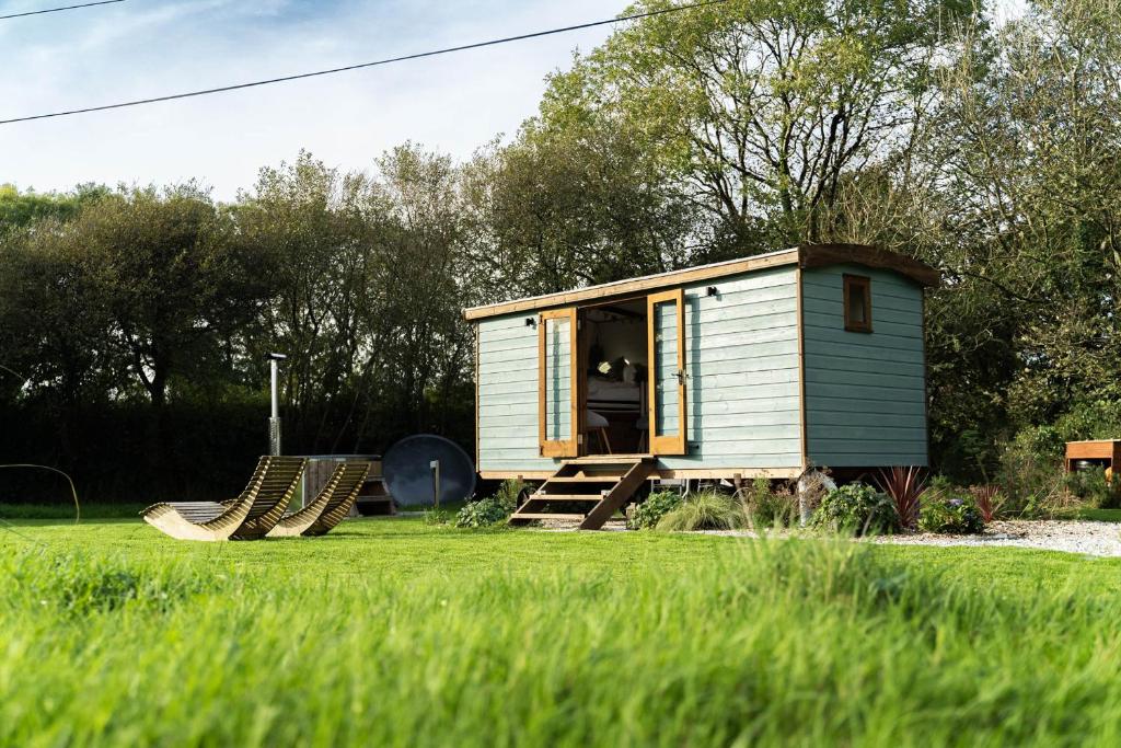 a tiny house in a field with a group of slides at Fern in Bude