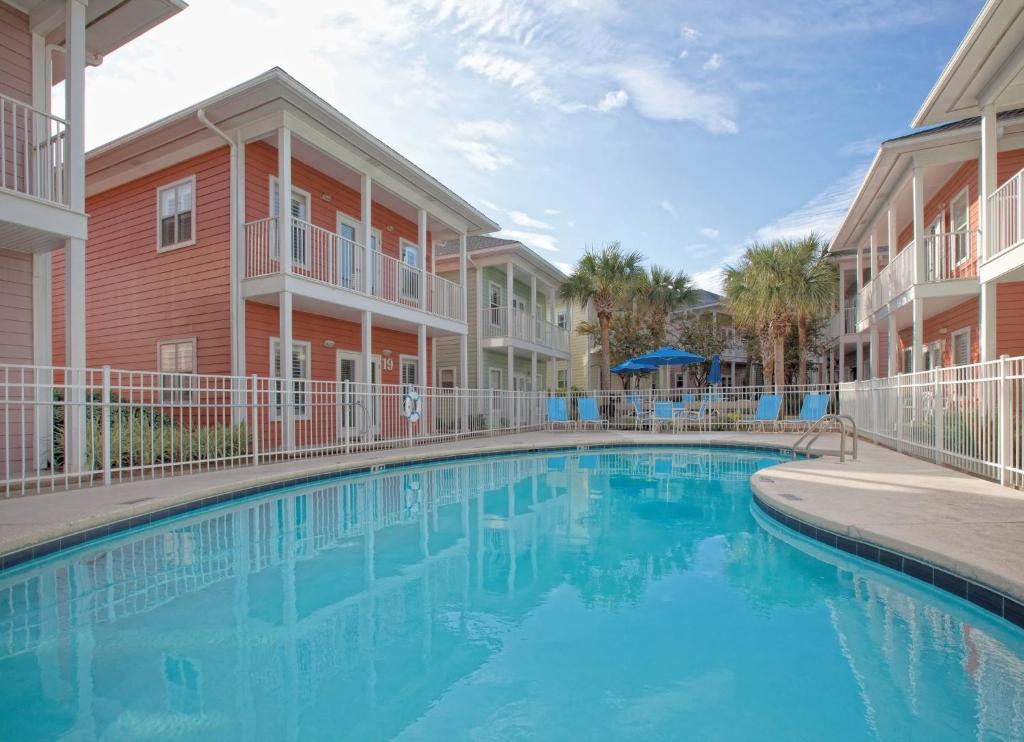 a swimming pool in the courtyard of a apartment building at Club Wyndham Beach Street Cottages in Destin