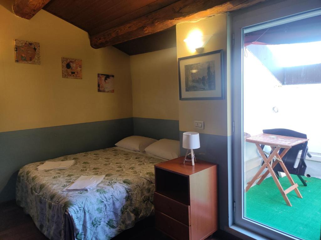 a small bedroom with a bed and a window at D'elite Apartment in Ferrara