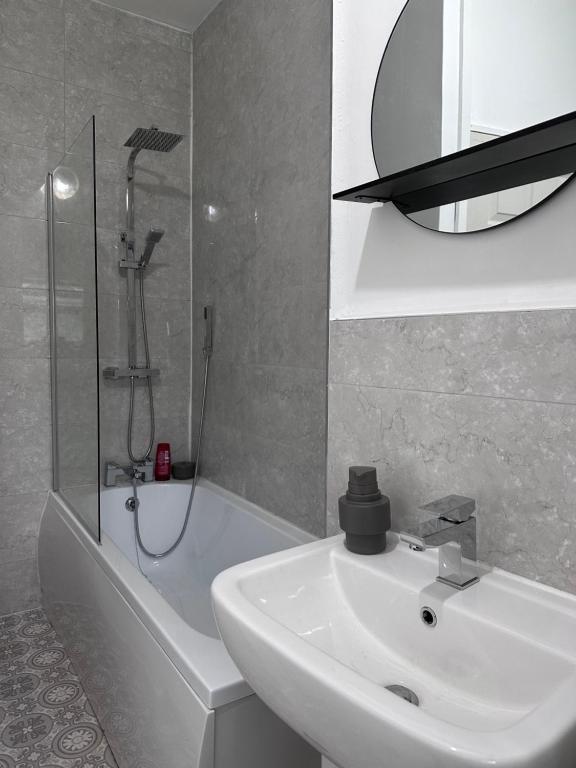 a white bathroom with a sink and a shower at Cosy Home in Manchester in Manchester