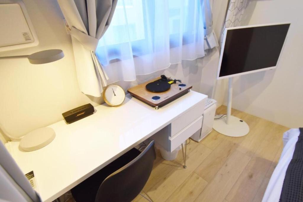un escritorio con reloj y un monitor en Ethos Ebisu 201 - Vacation STAY 09298v, en Tokio