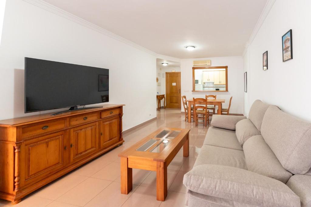 a living room with a couch and a flat screen tv at Apartamentos Solset Nerja in Nerja