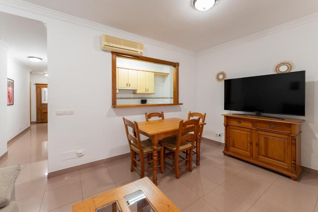 a dining room with a table and a flat screen tv at Apartamentos Solset Nerja in Nerja