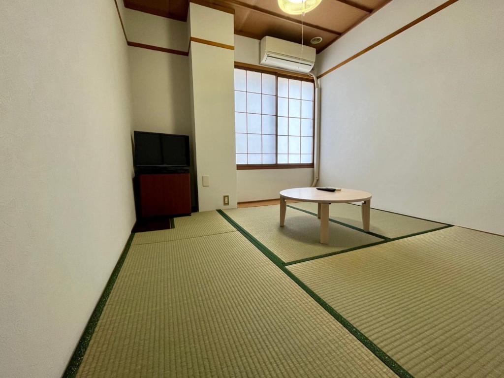 a room with a table and a tv in it at Yuzawa House - Vacation STAY 07080v in Yuzawa