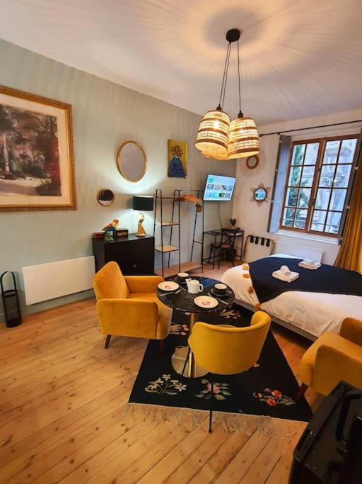 un salon avec un lit, une table et des chaises dans l'établissement Studio Basilique St Martin, à Tours