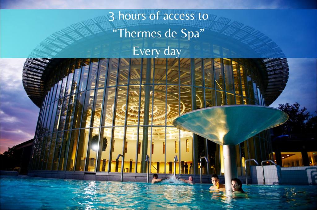 斯帕的住宿－Les Thermes de Spa by La Cour de la Reine Hôtel, Suites & accès gratuit au centre thermal，建筑前的一座带游泳池的建筑