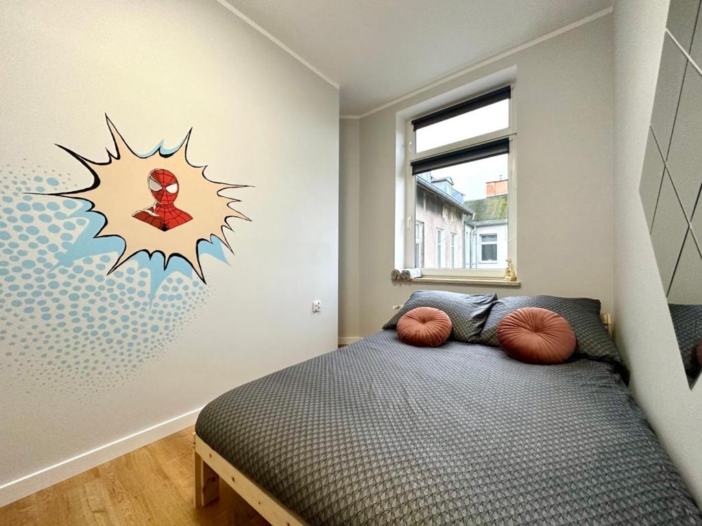 a bedroom with a bed with a spider on the wall at MMRent Spidey Room in Gdańsk