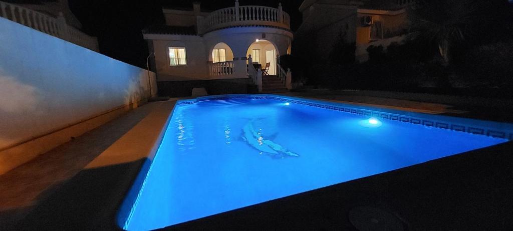 una piscina con una persona en el agua en Villa Bélgica en Gran Alacant, en Puerto Marino