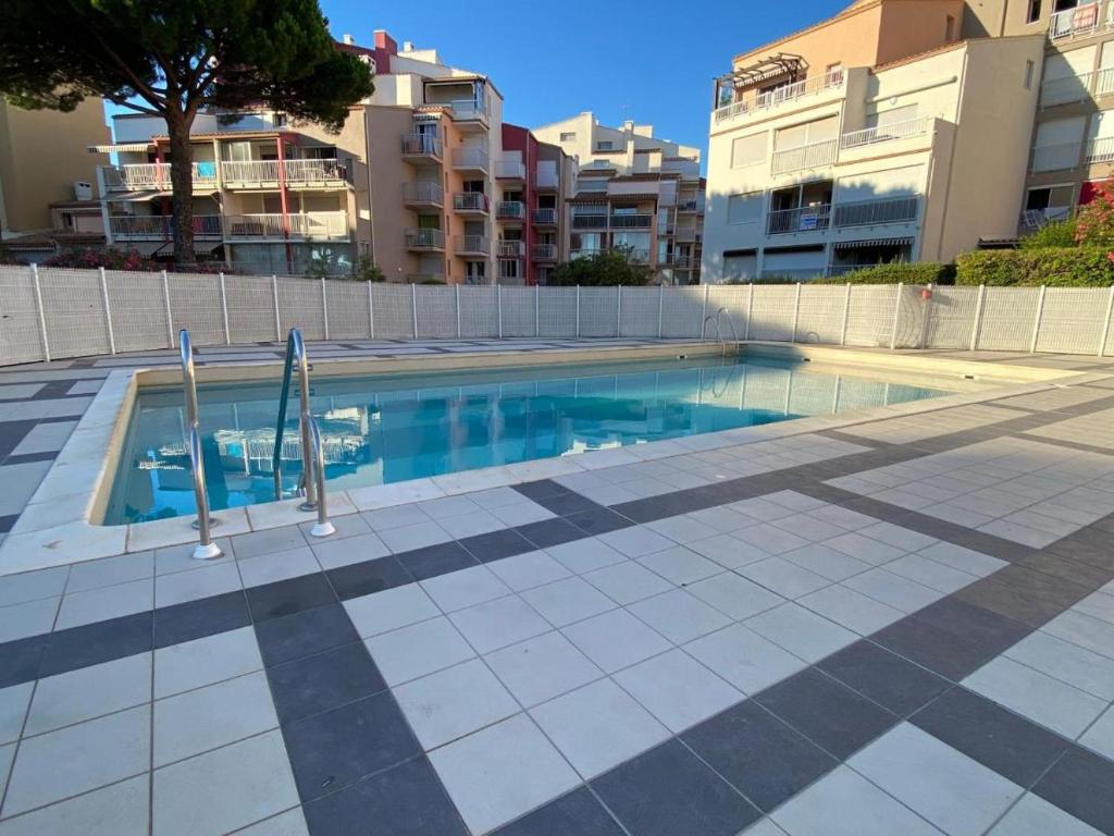 a swimming pool in front of some apartment buildings at Studio Cap d'Agde in Cap d'Agde
