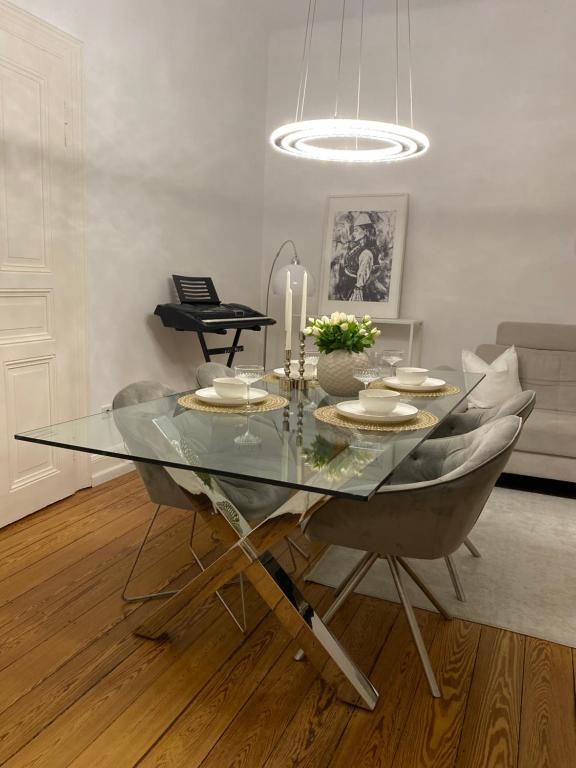 a dining room with a glass table and chairs at Altbau-Oase der Eleganz: Stadtnaher Komfort pur in Wiesbaden