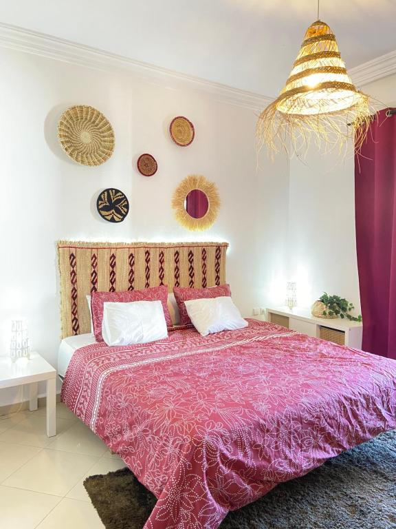 a bedroom with a bed with a purple comforter at Full Appartement Ville Haute in Kenitra