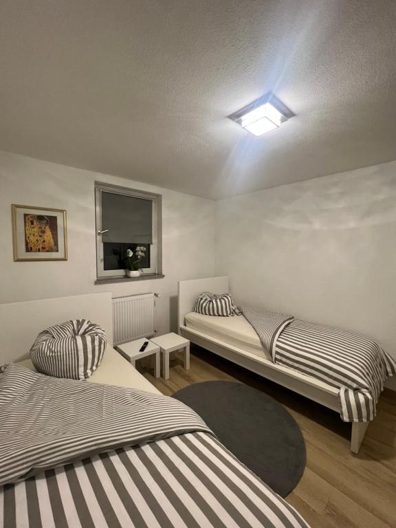 a room with two beds and a tv on the wall at Kiefern Apartments in Hannover
