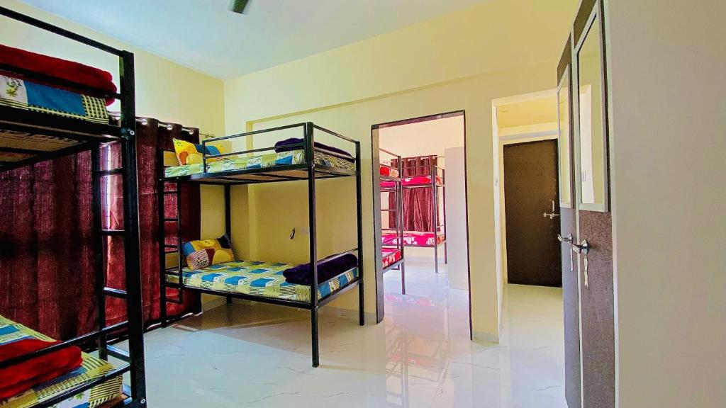 a room with two bunk beds and a mirror at The Peacewood's Homes - Pune's Comfort - Hostel & PG in Pune