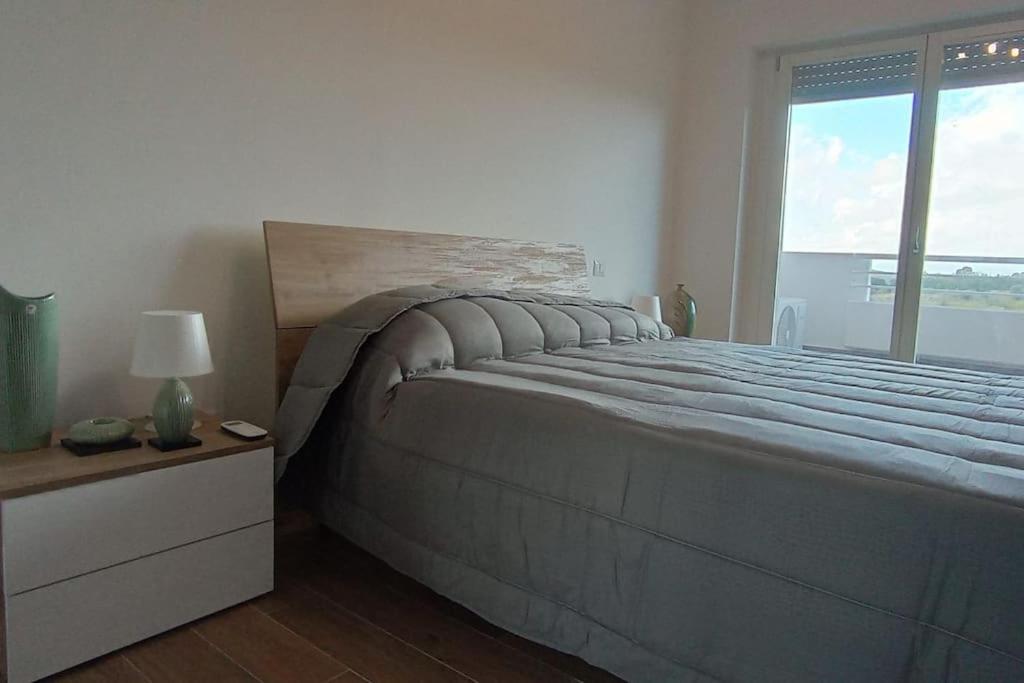 a bedroom with a large bed with a large window at Appartamento Le Vigne di Roma in Rome