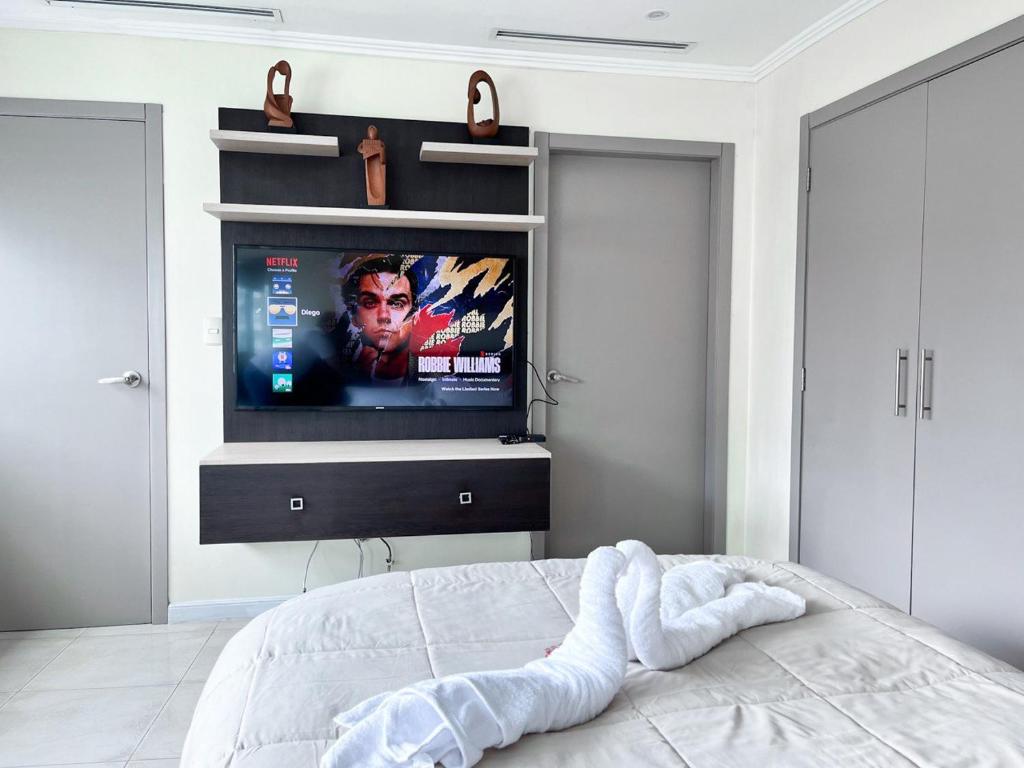 a bedroom with a bed with a flat screen tv at Depa de lujo con piscina y jacuzzi in Guayaquil