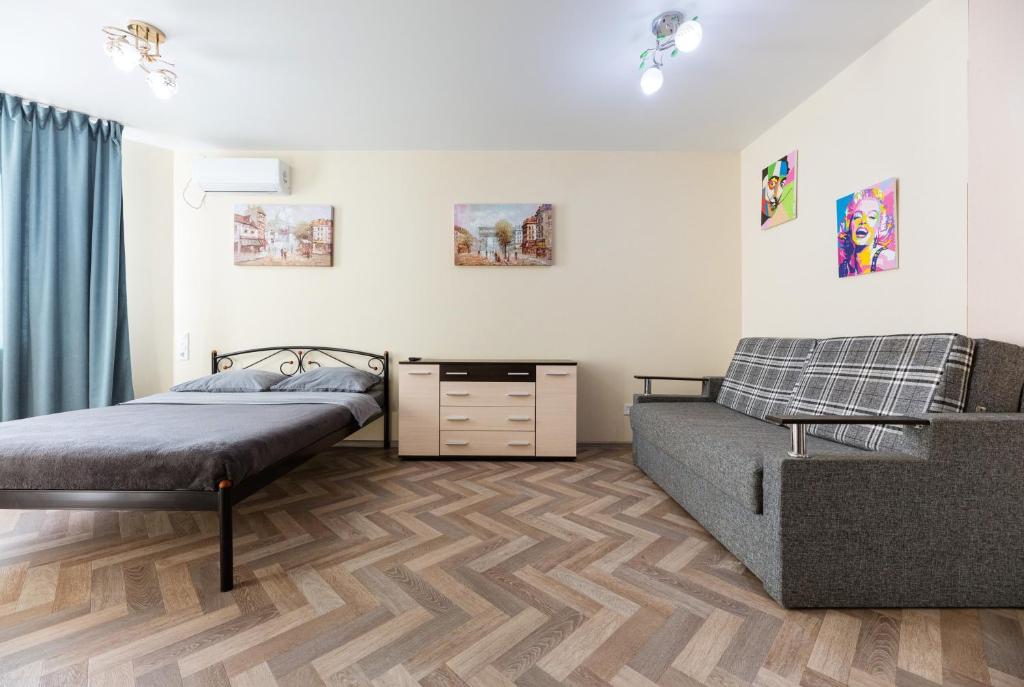 een slaapkamer met 2 bedden en een bank bij 0301 ComfortApartments JK Schastliviy Zhuliany Airport in Kiev