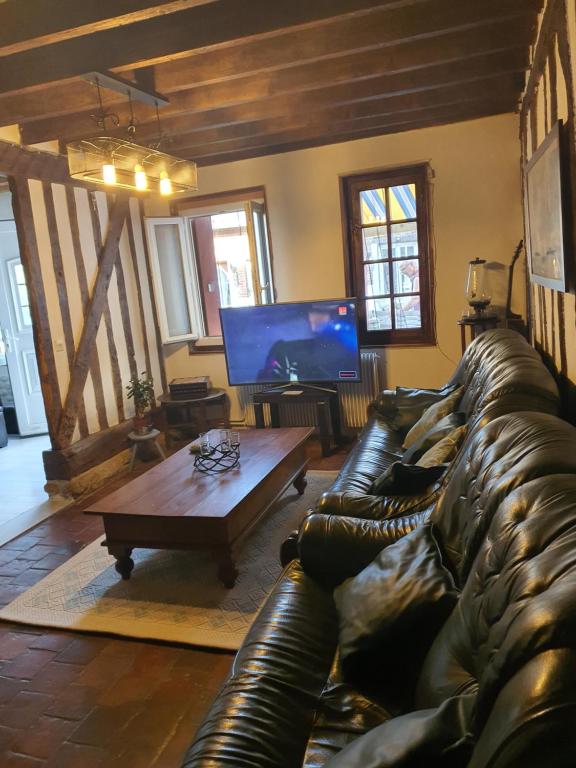 - un salon avec un canapé en cuir et une table basse dans l'établissement Maison Normandie, à Glos-sur-Lisieux