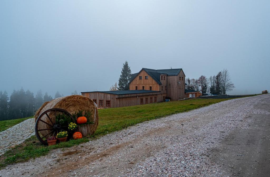 a hay wagon on a dirt road next to a house at Horská chata Krakonoš in Černý Dŭl