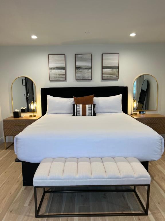 a large white bed with a bench in a bedroom at New Haven Inn in Solvang