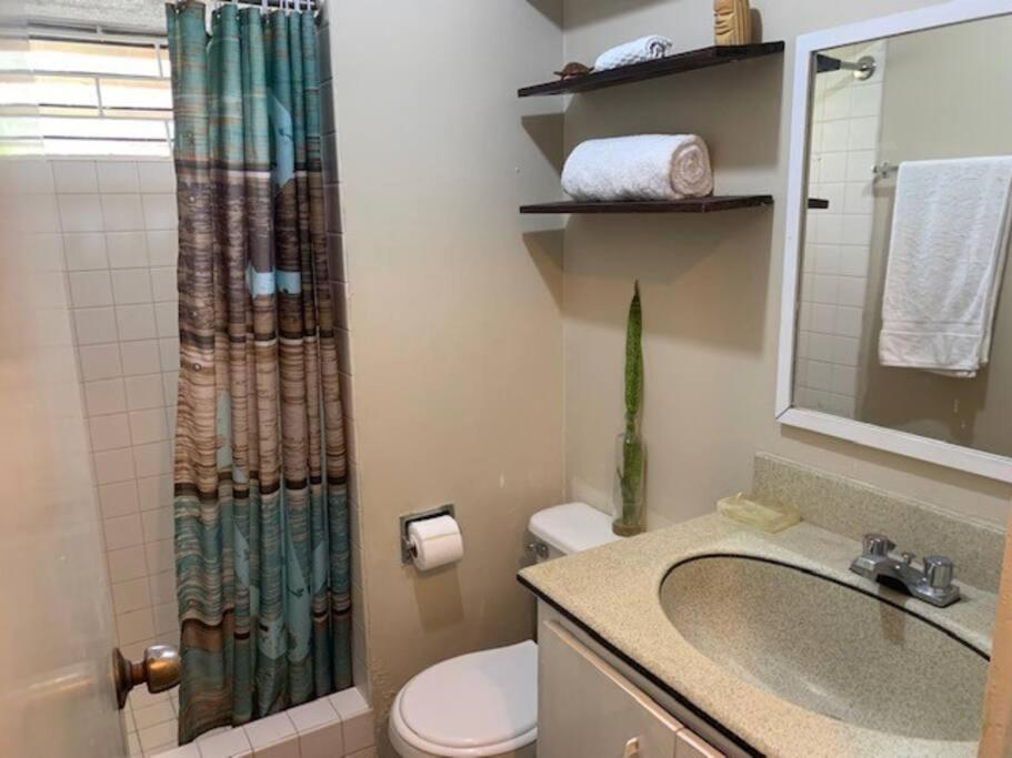 a bathroom with a sink and a shower curtain at Beach Townhouse, near hip strip, beach, airport in Montego Bay