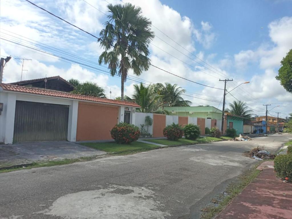 an empty street with houses and a palm tree at Pousada das Acacias in Carananduba