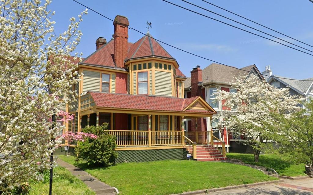 een groot huis met een rood dak bij Historic Escape in Mansion Row - Sleeps 12! in New Albany