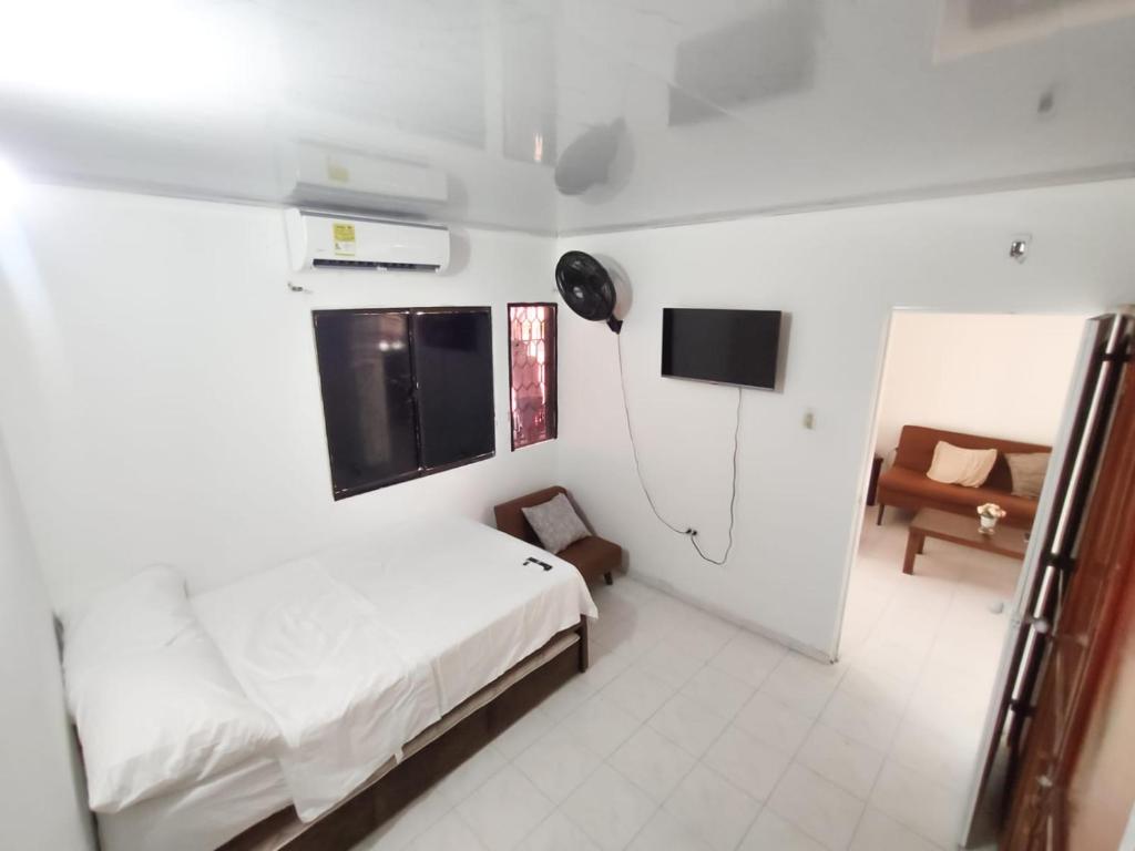 1 dormitorio con 1 cama y TV. en Hospedaje Casa Tito, en Santa Marta