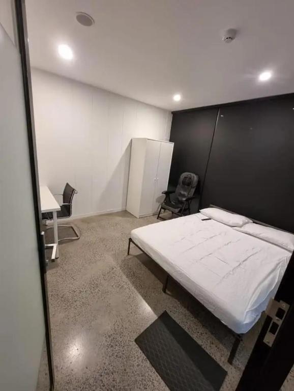 シドニーにあるSydney Airport Guest Houseのベッドとデスクが備わる客室です。