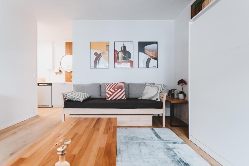 a living room with a couch and pictures on the wall at Scandic Primo Apartments - Design District 69m2 in Helsinki
